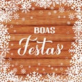 Boas Festas calligraphy on wood background with snowflakes. Happy Holidays hand lettering in Portuguese. Christmas typography Royalty Free Stock Photo