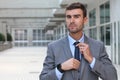 Boastful businessman adjusting his tie