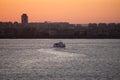 Boat in the Aegean Sea with Izmir skyline on orange and red sunset sky background in Turkey Royalty Free Stock Photo