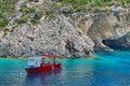 Blue water background. Boat anchored in bay - Ionian Sea, Zakynthos Island, landmark attraction in Greece. Seascape Royalty Free Stock Photo