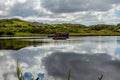 Boat anchored in the middle of Clifden bay at high tide, clouds reflected in the water