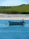 Boat is anchored near the picturesque shores of southern Ireland. Seaside landscape. Green hilly coast, boat on seashore Royalty Free Stock Photo