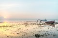 Boat Anchoring Near Beach or Seashore Full of Seaweed At Sunrise or Sunset with Yellow Pink Light Reflection on Water Surface. Sof