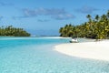 Boat anchoring on small island in turquoise clear water, deep blue sky, white sand, Pacific Island