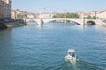 Boat approaching Pont Bonaparte bridge of Saone river near the Quais de Saone riverbank and riverside in the city center of Lyon Royalty Free Stock Photo