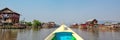 Boat arriving in a colorful floating village with stilt-houses in Burma Myanmar