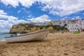 boat on beach in Carvoeiro village with colorful houses, Algarve region, Portugal