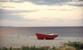 Boat on the beach. Fishermens boat at seacoast, on sand on cloudy day with sea on background. Fishing boat on beach in Royalty Free Stock Photo