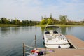 Boat berthed at small offshore planked floating dock in sunny wi