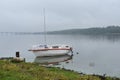 Boat boat sailboat with motor on the misty picturesque Bank of the river in the distance bridge water