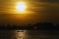 Boat on a calm river at sunset with sunlight reflecting on water