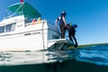 Boat Captain helping SCUBA diver out of water