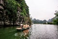 Boat cave tour in Trang An Scenic Landscape formed by karst towers and plants along the river (UNESCO World Heritage Site). It's