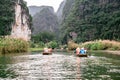 Boat cave tour in Trang An Scenic Landscape formed by karst towers and plants along the river (UNESCO World Heritage Site). It's