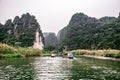 Boat cave tour in Trang An Scenic Landscape formed by karst towers and plants along the river (UNESCO World Heritage Site). It's