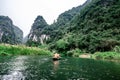 Boat cave tour in Trang An Scenic Landscape formed by karst towers and plants along the river (UNESCO World Heritage Site). It's