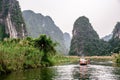 Boat cave tour in Trang An Scenic Landscape formed by karst towers and plants along the river (UNESCO World Heritage Site). It's