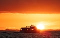 Boat by the coast of Belize with Sun behind it Royalty Free Stock Photo