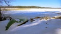 Boat and pier at the edge of a frozen lake in Finland.