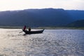 A boat croos the river with blue sky and hill