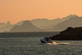 Boat disapearing in the horizon, layers of mountains in Lofoten, Norway.