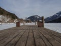 Boat dock in frozen lake in the background mountains Royalty Free Stock Photo