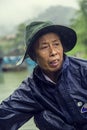 Boat driver in Phong Nha River under the rain. Phong Nha, Vietnam. Royalty Free Stock Photo