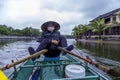 Boat driver in Phong Nha River under the rain. Phong Nha, Vietnam. Royalty Free Stock Photo