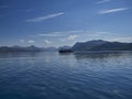 Boat driving across a deep blue lake in the scottish highlands Royalty Free Stock Photo