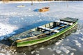 Boat at the edge of a frozen river on a sunny winter day Royalty Free Stock Photo