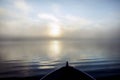 Boat entering a fog bank at sunrise Royalty Free Stock Photo