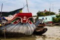 Boat with eyes and anchor painting decoration on the prow, anchored in the muddy waters of the Mekong Delta, Vietnam