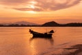 Boat of fisherman on the beach with silhouette orange light before sunset and mountain background Asia Thailand Royalty Free Stock Photo