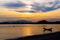 Boat of fisherman on the beach with silhouette orange light before sunset and mountain background Asia Thailand Royalty Free Stock Photo