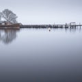 Boat in fog mist and jetty pier wooden on lake Loch Lomond Balmaha tranquility peace mindfulness