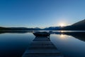 Boat in front of a wooden pier in lake McDonald at sunset in Montana, United States Royalty Free Stock Photo