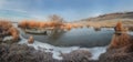 A boat on a frozen river near the shore. Dry reeds and willow trees. Winter panorama of a river or lake Royalty Free Stock Photo