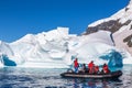 Boat full of tourists explore huge icebergs drifting in the bay