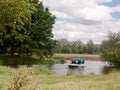 A boat going down a river outside in england country summer Royalty Free Stock Photo