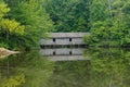 a boat house sitting in the middle of a lake surrounded by trees Royalty Free Stock Photo