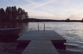 Boat and jetty by lake in beautiful sunset.