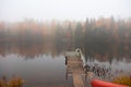 Boat Jetty in lake with fog and foliage