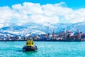 Batumi, Georgia. February 21, 2021 - Boat in the port against the backdrop of beautiful snow-capped mountains