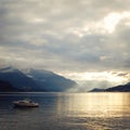 Boat on Lake Como at the sunset. Silver linings. Royalty Free Stock Photo