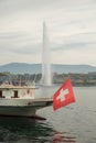 Boat on lake Leman with swiss flag in the front