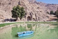 Boat on the lake of mountains with ancient Arches of Taq-e Bostan Royalty Free Stock Photo