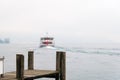 Boat leaving pier at Lucerne or Luzern lake Switzerland with heavy fog