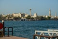 Boat marina on the canal in the middle of the city. View of Dubai Creek from the Deira area. Wooden platforms near blue water