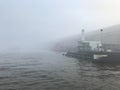 Boat in the mist in Amsterdam harbor Royalty Free Stock Photo