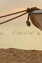 Boat moored on beach at sunset